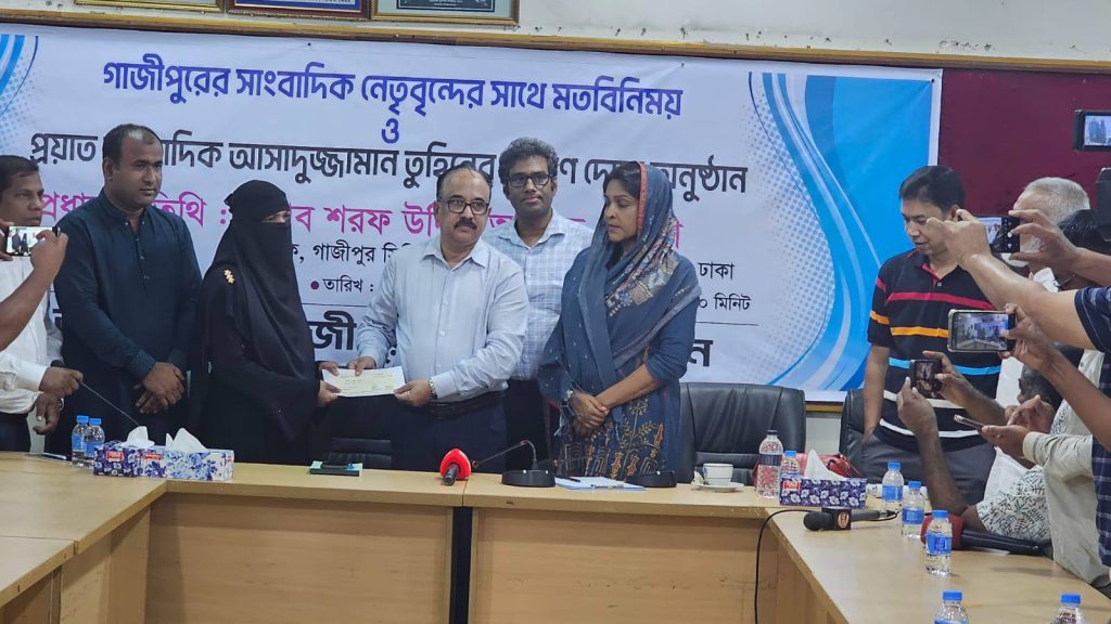 নিহত সাংবাদিকের পরিবারের হাতে চেক তুলে দিচ্ছেন